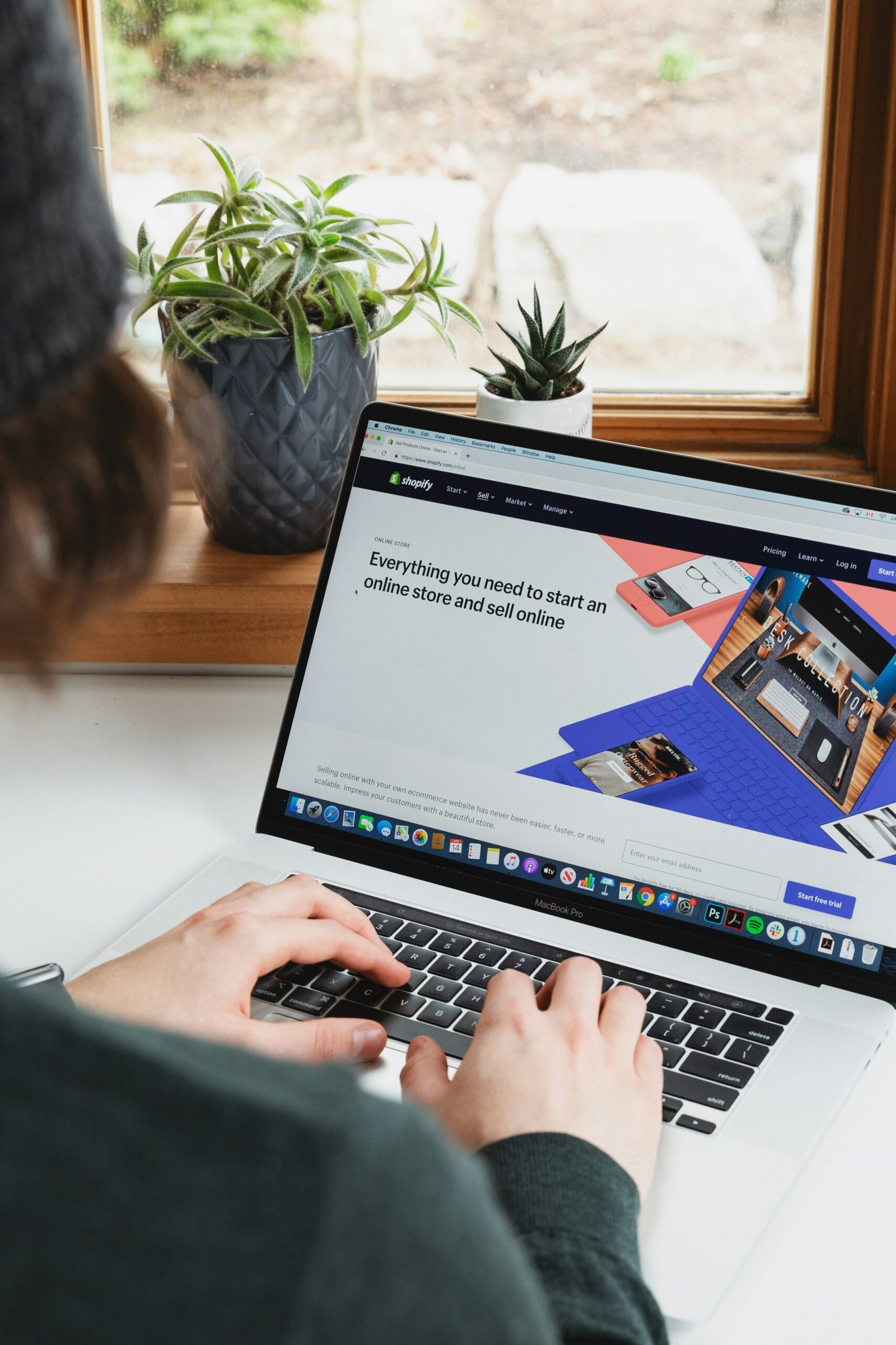 person using macbook pro on white table